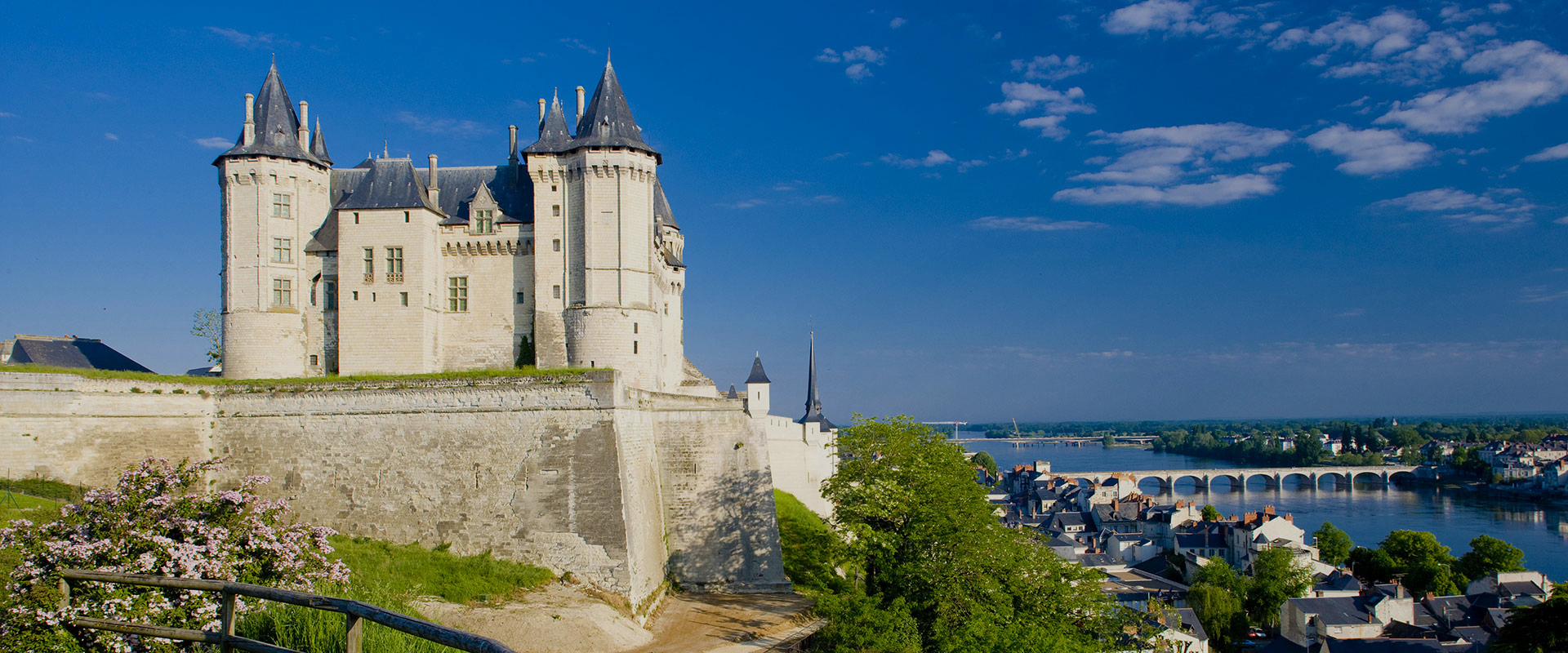 paysage château et forteresse surplombant un village et un fleuve représentant les Pays de la Loire