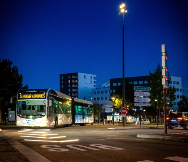Bus de nuit dans les rues de Nantes, qui avance en suivant la signalisation dynamique lumineuse Flowell qui marque la chaussée