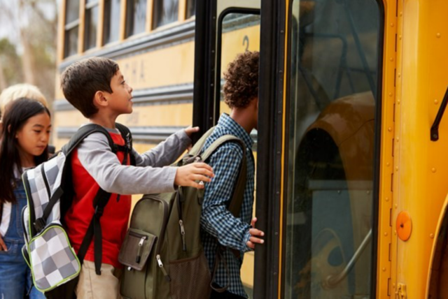 Children getting on a yellow school bus