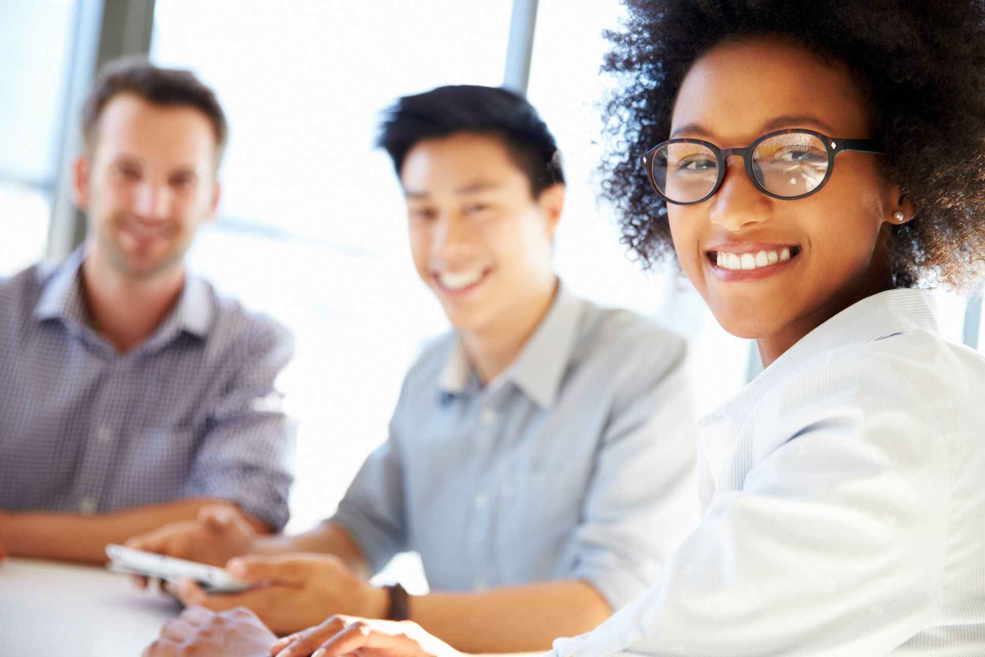 Trois jeunes professionnels souriants travaillent