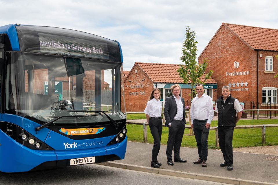 Group of people welcomes York and Country blue bus to Germany Beck, Fulford, York