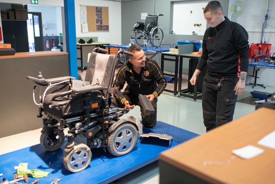 Personnes travaillant sur un fauteuil roulant